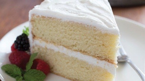 Slice of yellow cake with white frosting