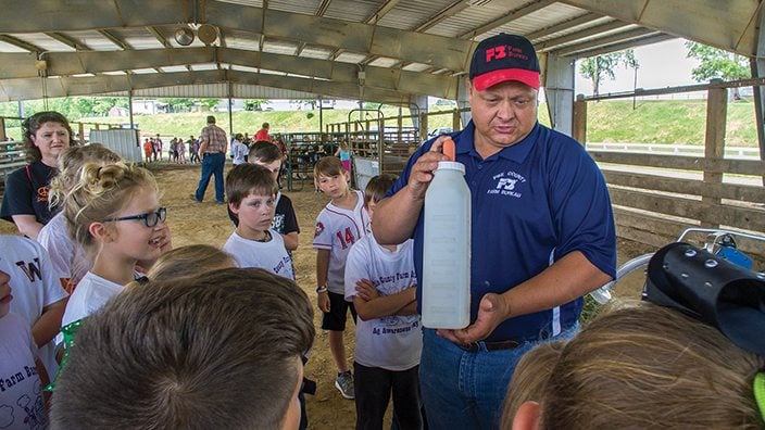 Pike County Farm Bureau Board Trustee Steven Brunner of Brunner Farms talked to students about taking care of dairy cows, including baby calves.