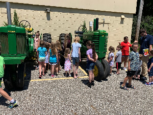 The children getting up close and personal with John Deere Tractors from Mr. Baker